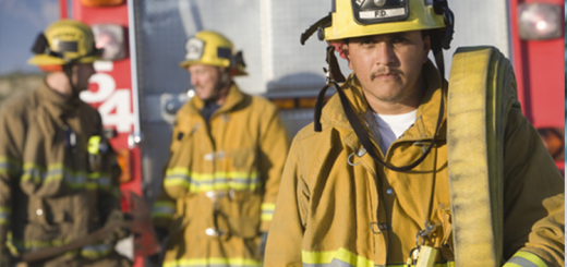 Fire fighter with hose looking at camera